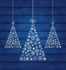 Image showing Holiday wooden background with Christmas pines made of snowflake