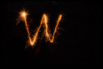 Image showing Letter W made of sparklers on black