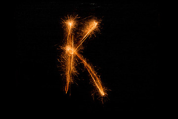 Image showing Letter K made of sparklers on black