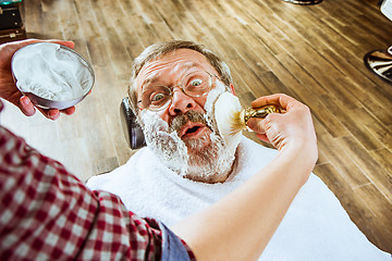 Image showing The senior man visiting hairstylist in barber shop.