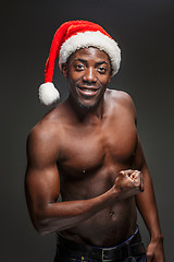 Image showing Muscular black shirtless young man in Santa Claus hat