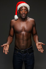 Image showing Muscular black shirtless young man in Santa Claus hat