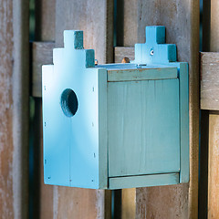 Image showing Blue birdhouse on a wooden fence