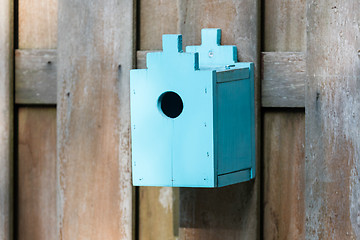 Image showing Blue birdhouse on a wooden fence