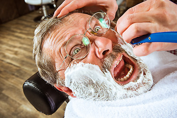 Image showing The senior man visiting hairstylist in barber shop.