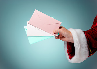 Image showing Hand in costume Santa Claus is holding the envelopes