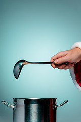 Image showing The Santa hand holding a ladle or kitchen spoon