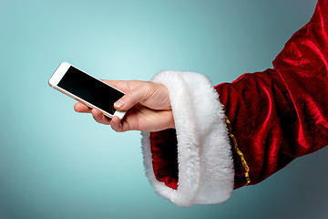 Image showing Santa Claus holding mobile smartphone ready for Christmas time