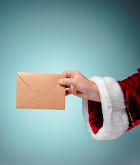 Image showing Hand in costume Santa Claus is holding the envelope