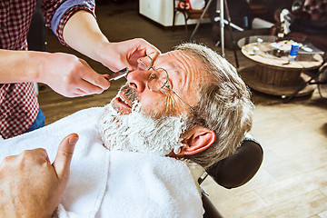 Image showing The senior man visiting hairstylist in barber shop.