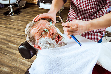 Image showing The senior man visiting hairstylist in barber shop.