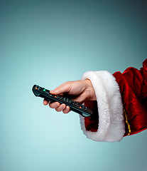 Image showing Santa Claus holding tv remote control