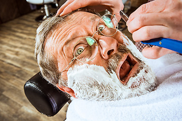 Image showing The senior man visiting hairstylist in barber shop.