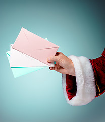 Image showing Hand in costume Santa Claus is holding the envelopes