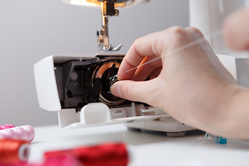 Image showing Hand with spool of sewing-machine