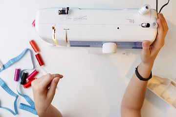 Image showing Girl preparing work on sewing-machine