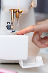 Image showing Seamstress put thread in needle