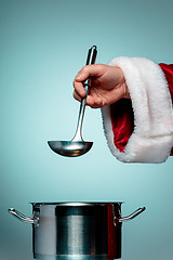 Image showing The Santa hand holding a ladle or kitchen spoon