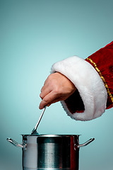 Image showing The Santa hand holding a ladle or kitchen spoon