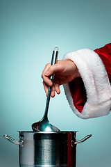 Image showing The Santa hand holding a ladle or kitchen spoon