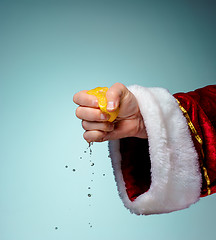 Image showing Photo of Santa Claus hand squeezing lemon