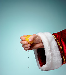 Image showing Photo of Santa Claus hand squeezing lemon