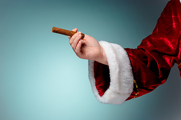 Image showing Photo of Santa Claus hand with a cigar