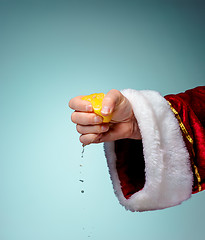 Image showing Photo of Santa Claus hand squeezing lemon
