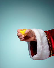 Image showing Photo of Santa Claus hand squeezing lemon