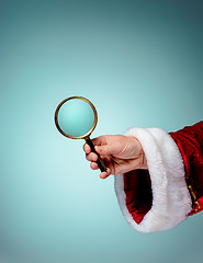 Image showing Photo of Santa Claus hand with a magnifying glass