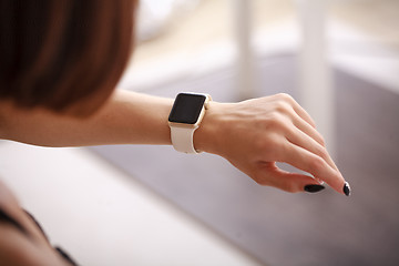 Image showing using her smartwatch at home in the living room