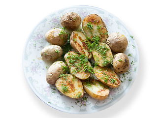 Image showing Russian Traditional baked potatoes with the peel and fennel, drizzled oil on a plate gray ornament