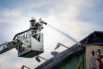 Image showing Firefighters in action fighting, extinguishing fire, in smoke.