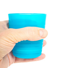 Image showing Empty blue plastic glass, held in a male persons hand