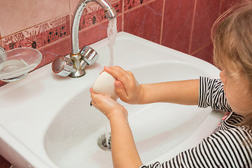 Image showing Five-year girl soaps hands with soap in the sink