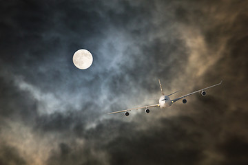 Image showing Long-haul night flight through clouds in light of full moon