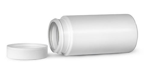 Image showing White plastic bottle for vitamins lying near lid