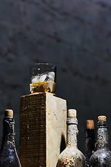 Image showing Glass of whiskey with ice on old wooden bar