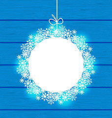 Image showing Christmas round frame made in snowflakes on blue wooden backgrou