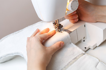 Image showing Woman starts tailoring on sewing-machine
