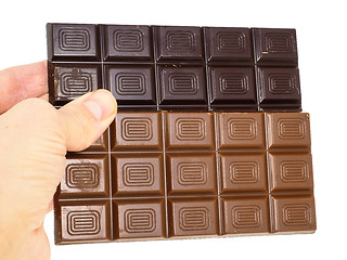 Image showing Person holding two whole bars of light and drak chocolate isolat