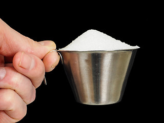 Image showing Person holding a measuring cup of one deciliter filled up with w