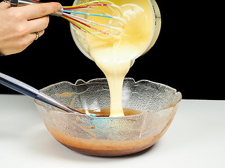 Image showing Female person pouring Gogl-Mogl, into a glass bowl with chocolat