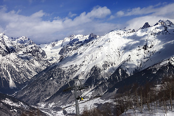 Image showing Ski-lift with skiers at winter sun day