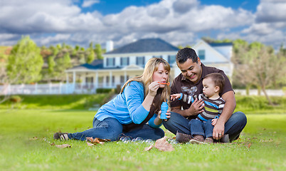 Image showing Happy Mixed Race Ethnic Family Playing with Bubbles In Front Yar