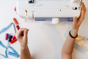 Image showing Seamstress preparing work on sewing-machine