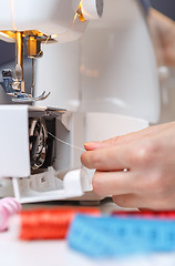 Image showing Woman put thread in sewing-machine