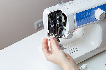 Image showing Young man repairing sewing machine