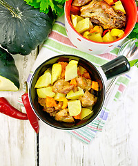 Image showing Roast meat and vegetables in white pots on board top