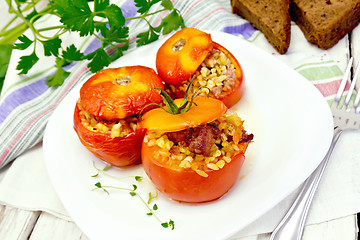 Image showing Tomatoes stuffed with bulgur and meat in plate on board